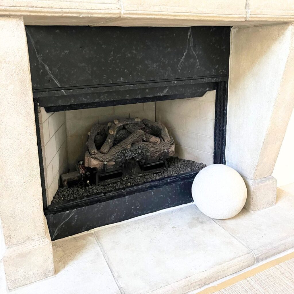 A before and after image of a damaged electric fireplace transformed into a beautiful granite masterpiece.