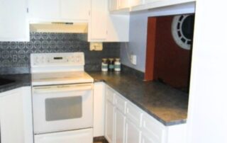 DIY kitchen cabinet makeover with painted shaker-style doors and faux granite countertops